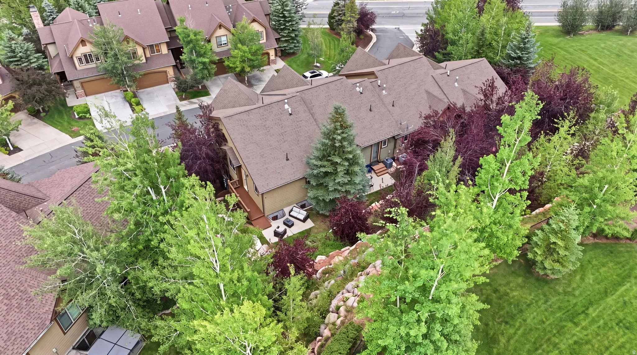 Expansive property featuring a multi-level roofline, extensive natural landscaping, and a private back patio