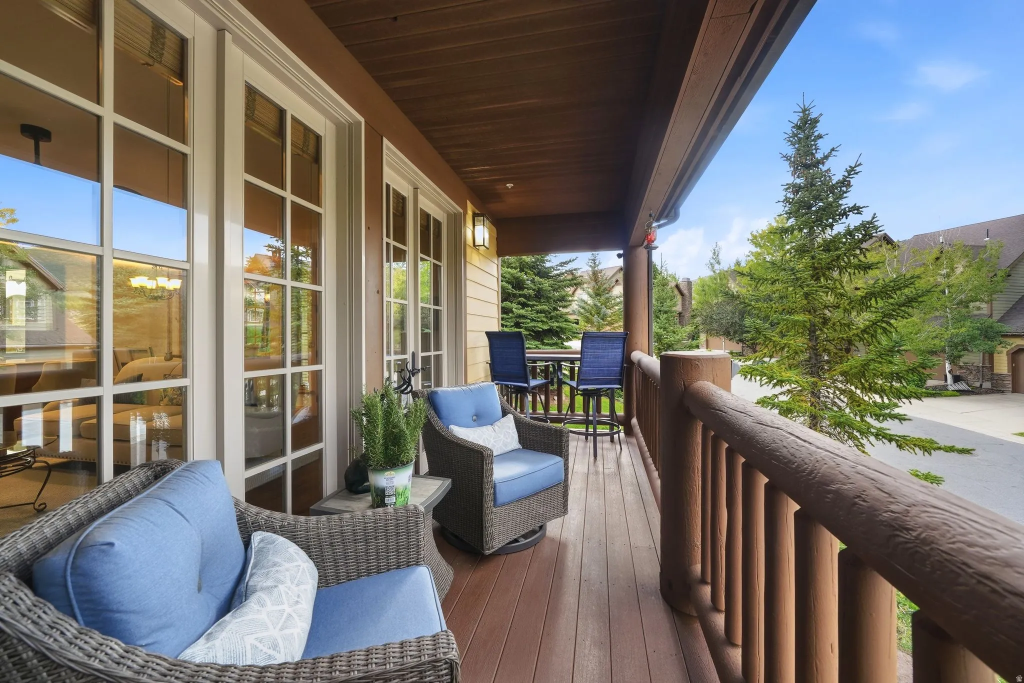 Covered porch featuring a wood-finish deck and log railing