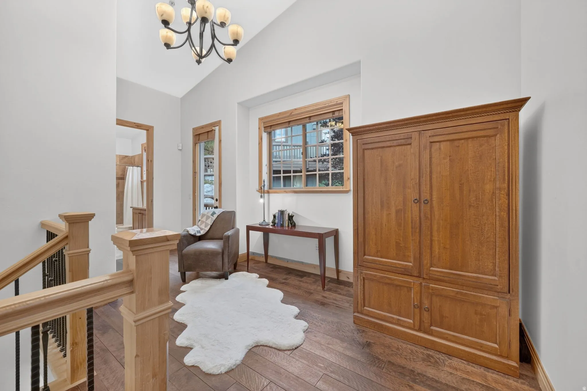 Loft area with vaulted ceiling and chandelier lighting
