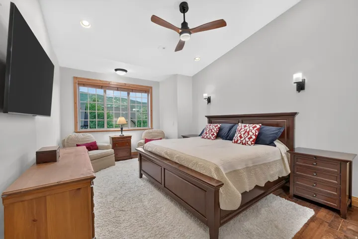 Spacious room featuring vaulted ceilings, recessed lighting, and a prominent window with wood-finish trim