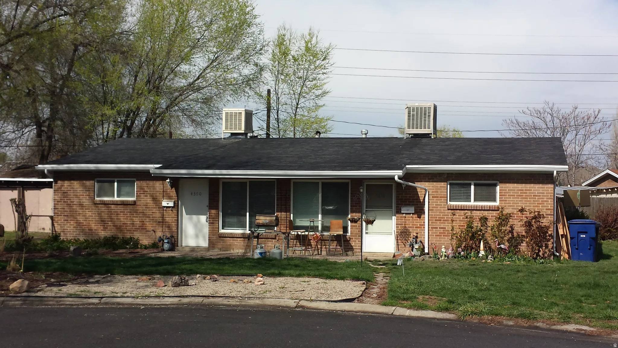 Brick exterior featuring a black shingle roof and white gutters