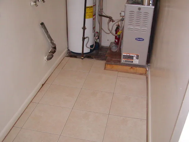 Utility area with light-toned ceramic tile flooring, a water heater, and a furnace unit