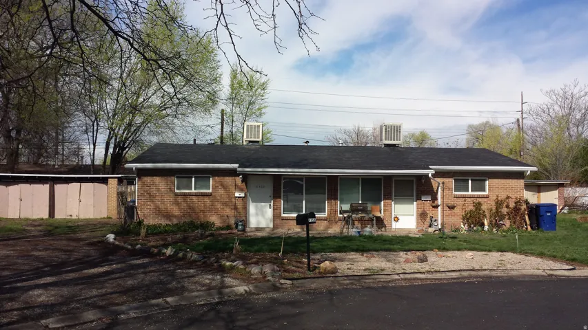 Brick exterior with a dark shingle roof and white gutters