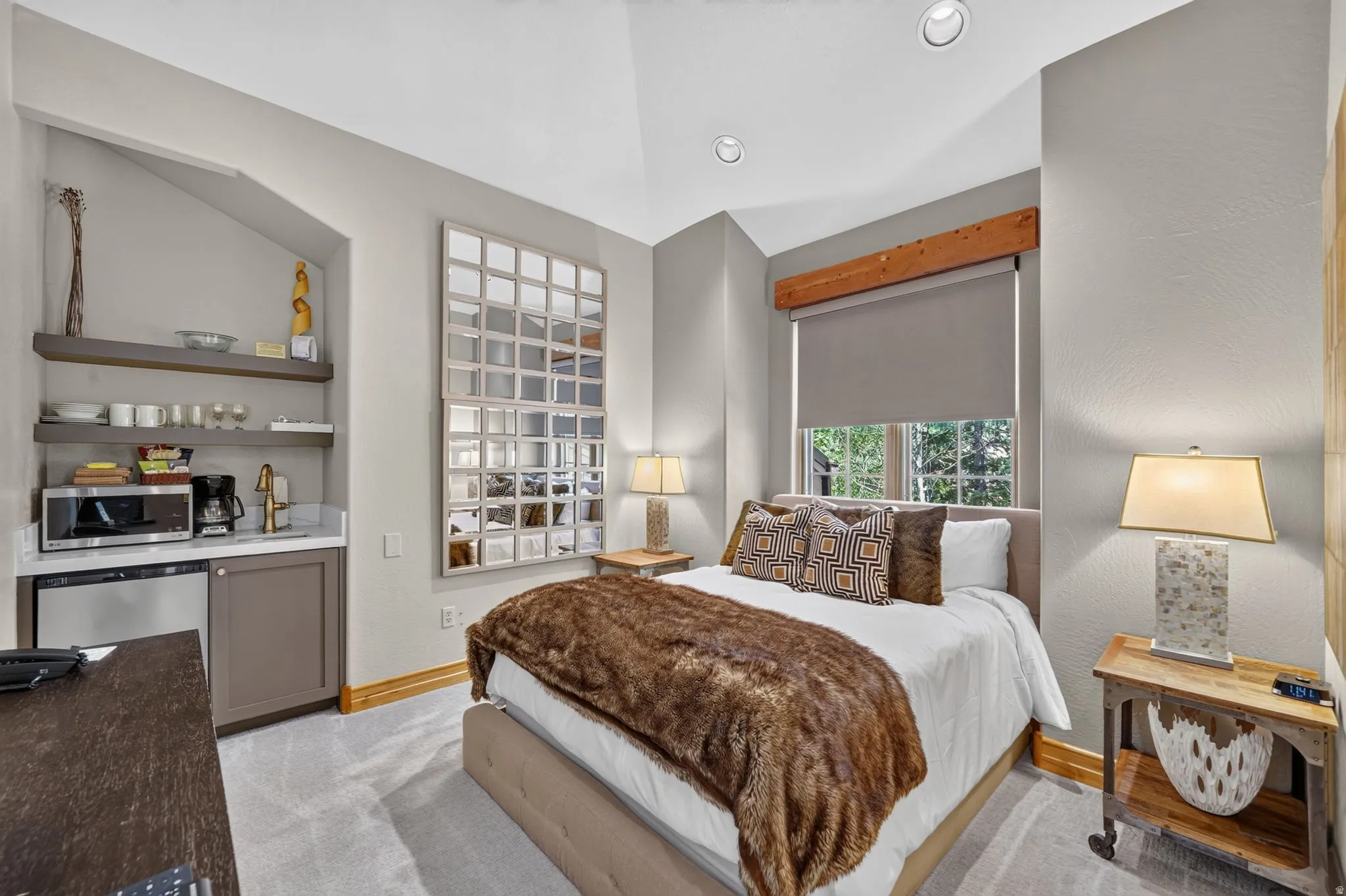 Carpeted room featuring a built-in mini-bar with a sink, microwave, and under-counter refrigerator