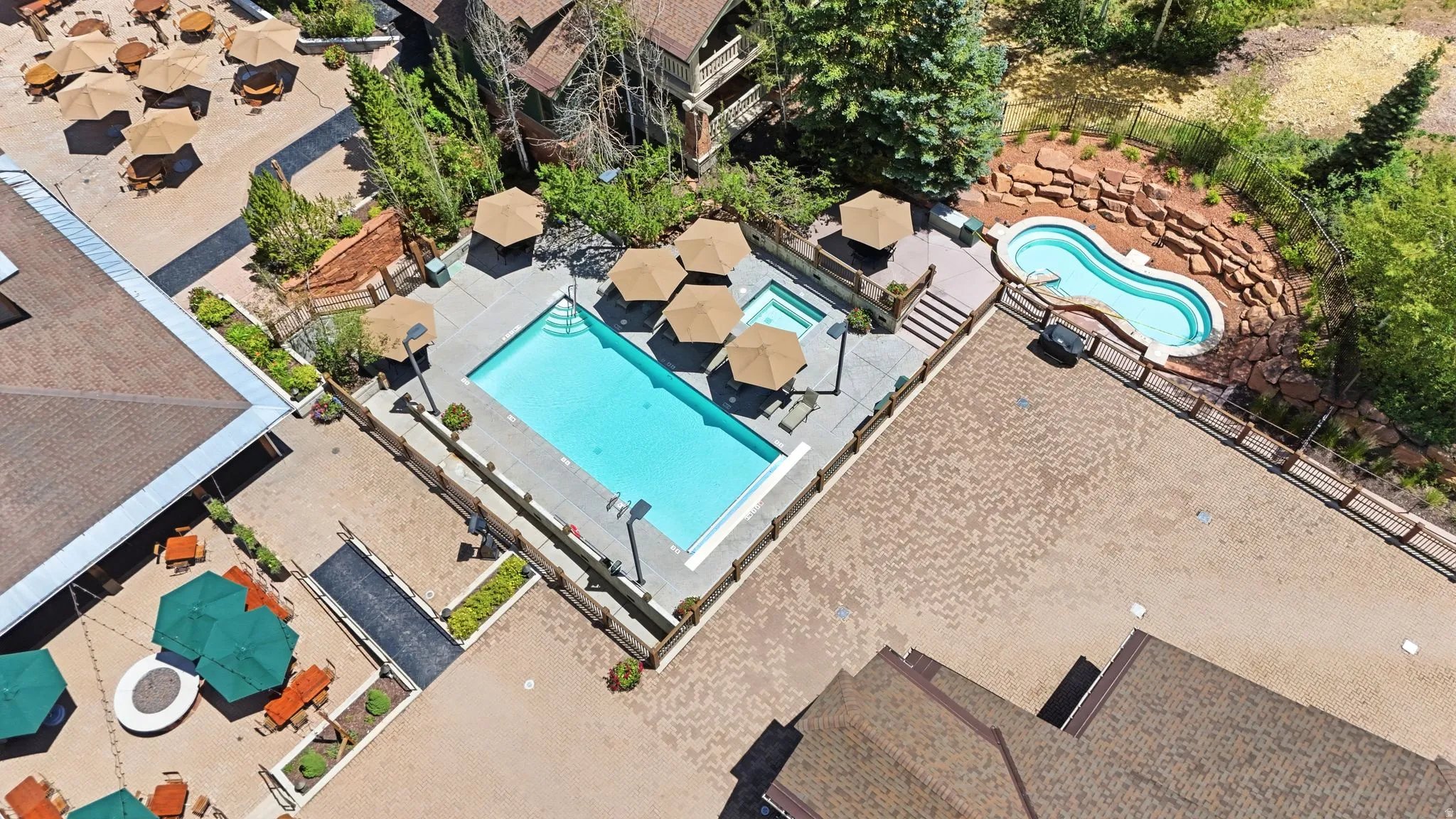 Multiple outdoor pools and hot tubs featuring surrounding paved patios