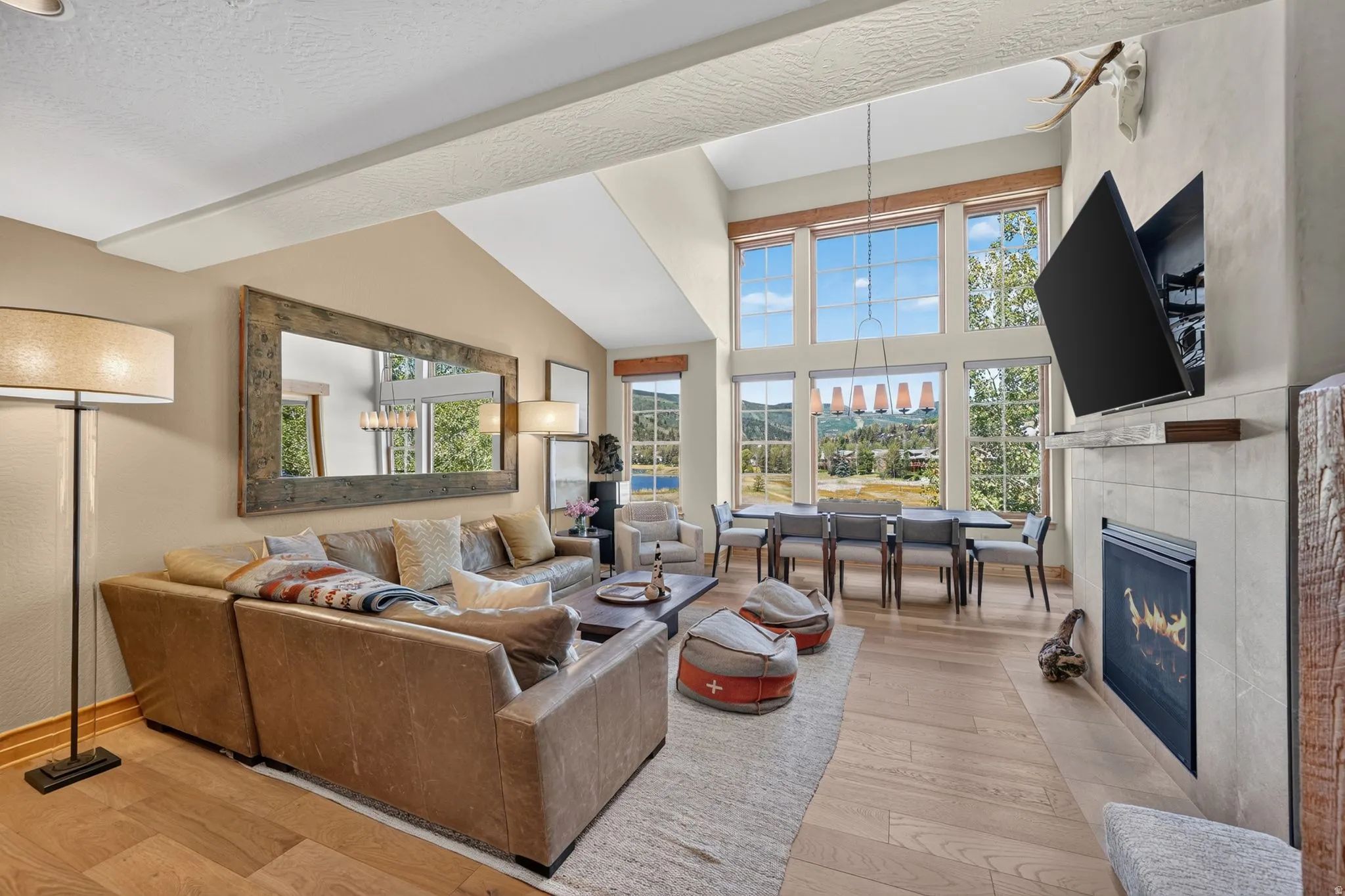 Vaulted ceilings with exposed beams complement the light wood-finish flooring