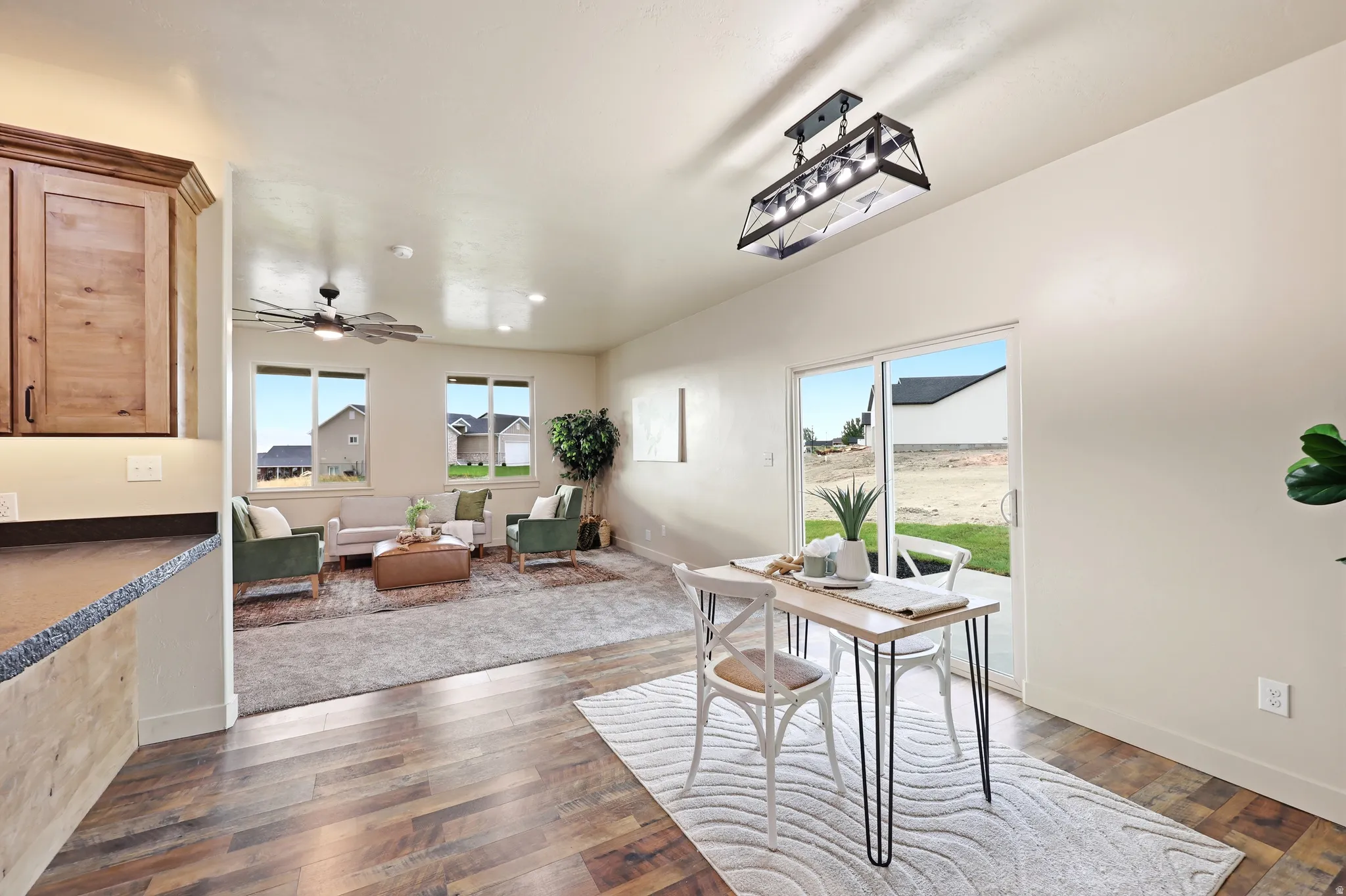 Open-concept living space featuring wood-finish flooring, a contemporary ceiling fan, recessed lighting, and sliding glass door access to the outdoor area