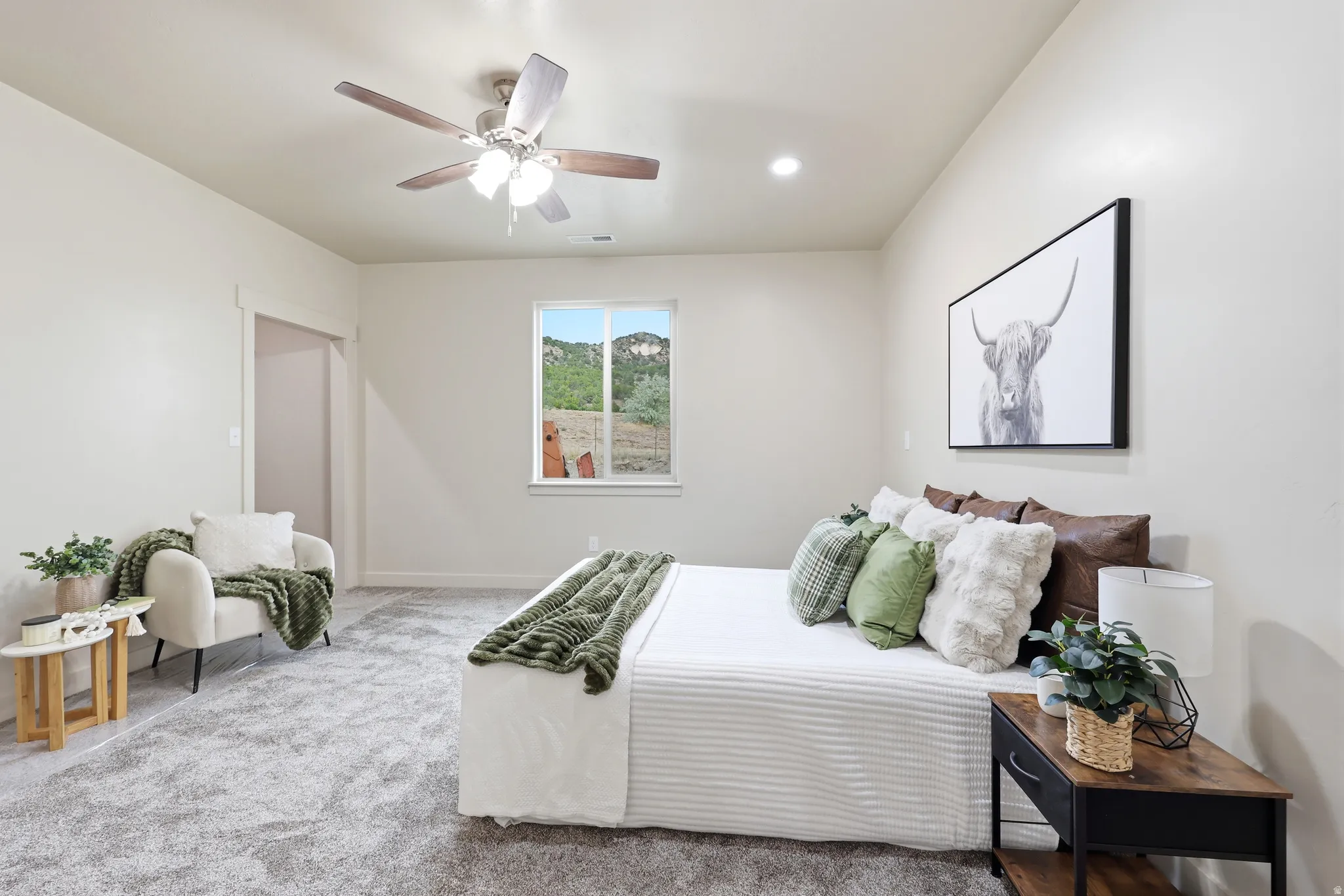 Spacious room featuring light-colored walls and soft gray carpeting