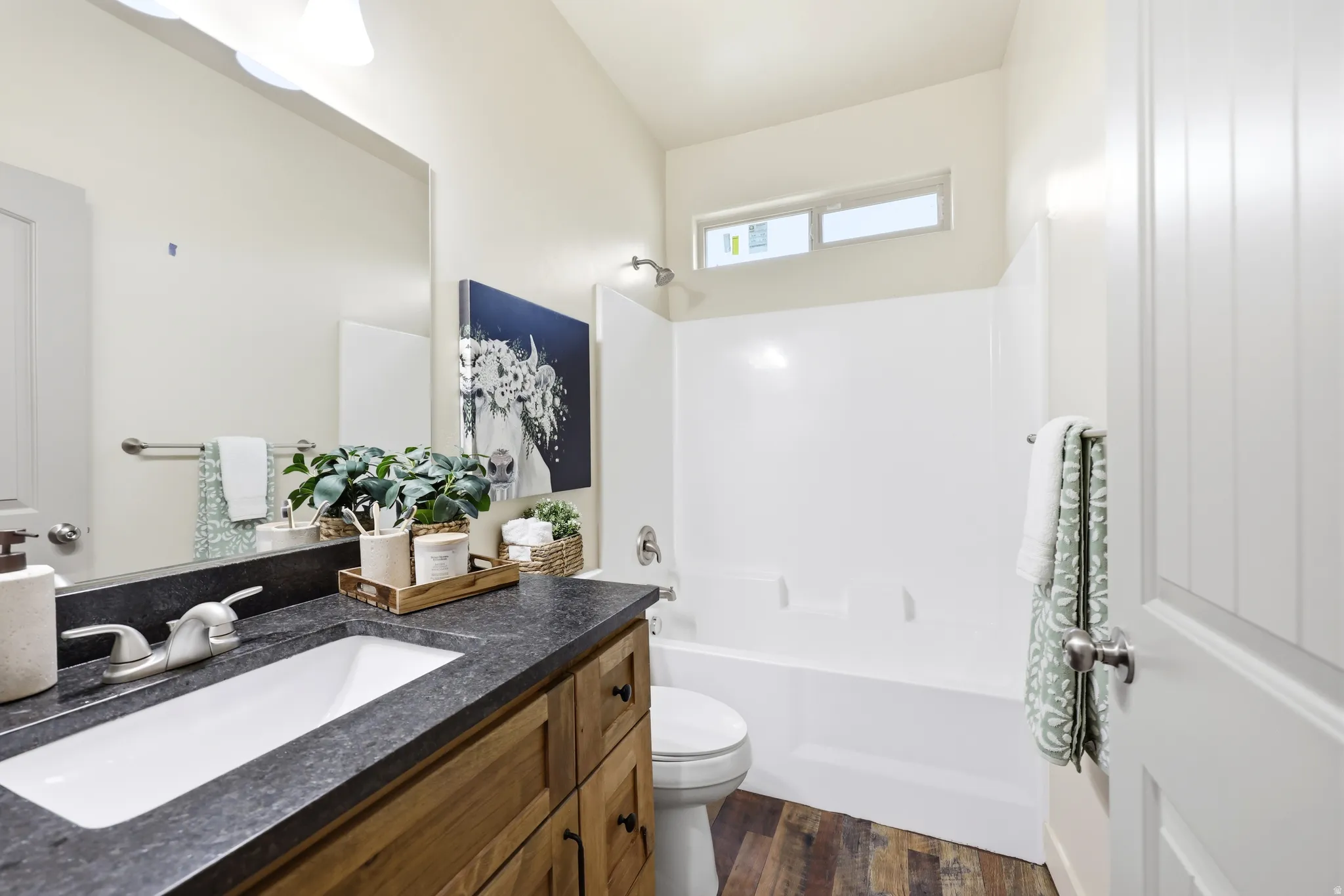 Bathroom featuring a wood-finish vanity with a dark countertop and integrated sink