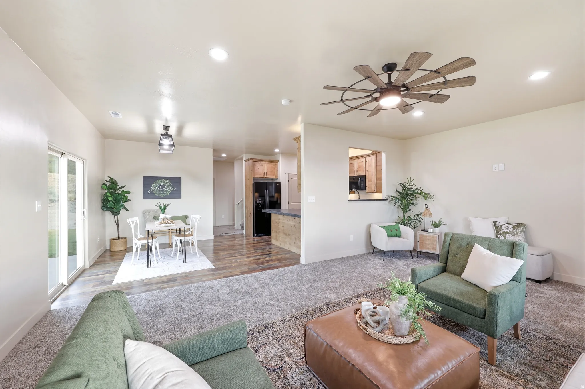 Spacious open-concept living area featuring recessed lighting, a decorative ceiling fan, and sliding glass doors