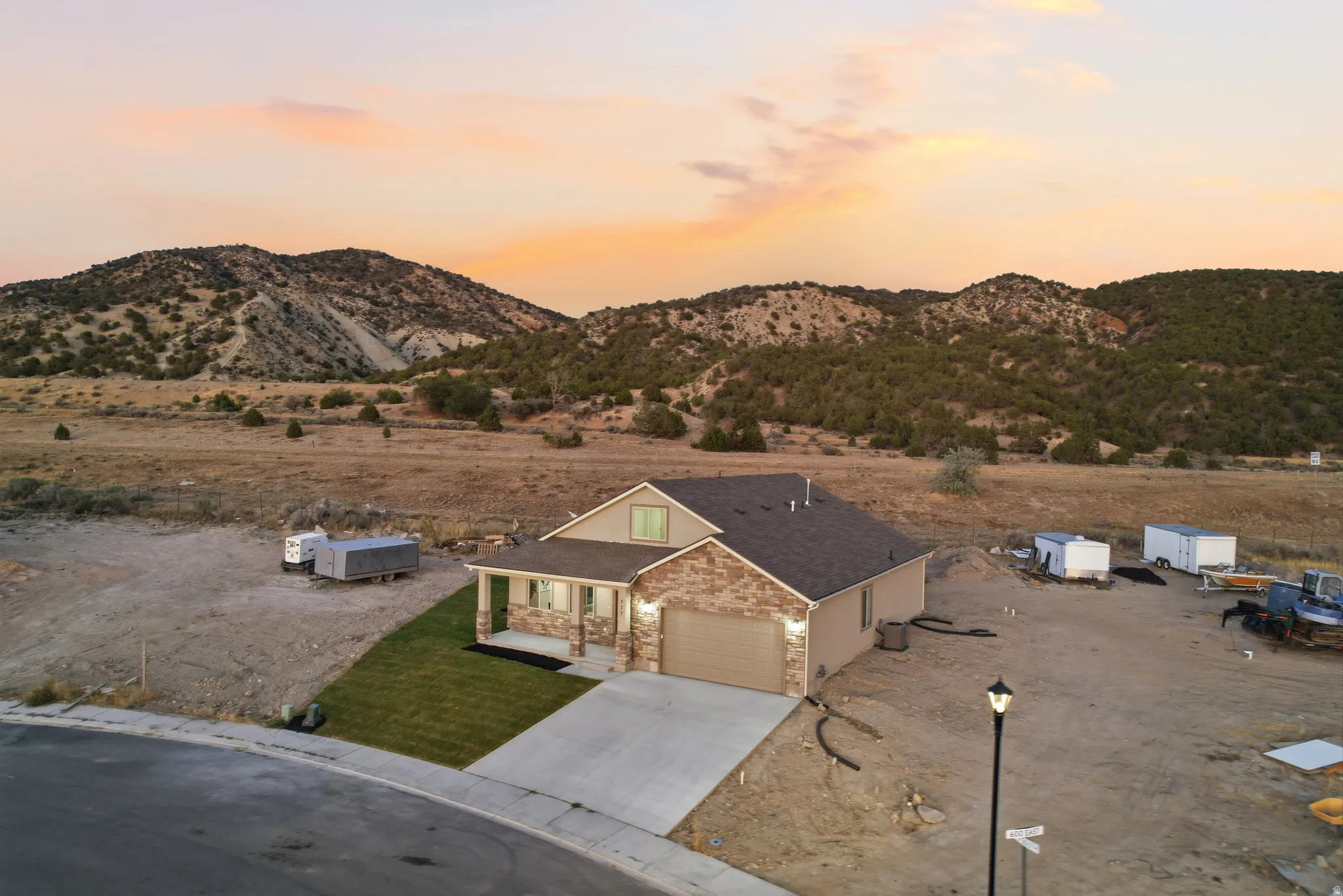 Contemporary ranch-style residence featuring a stone and stucco exterior, an attached two-car garage, and a covered porch
