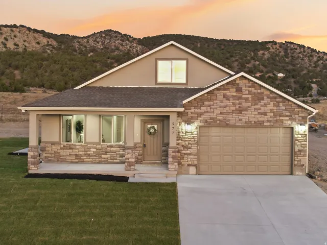 Contemporary home with a stone and stucco exterior, featuring a covered front porch, an attached garage, and a concrete driveway