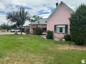 Pink exterior residence featuring a gabled roofline and a prominent chimney