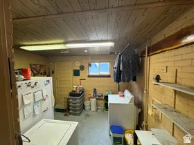 Laundry area featuring a wood-panel ceiling, fluorescent lighting, and a single window