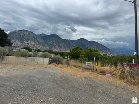 Mountain backdrop with surrounding vegetation and a partially paved surface