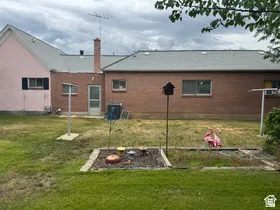 Rear exterior featuring a brick facade and a light pink stucco section with a dark-shuttered window