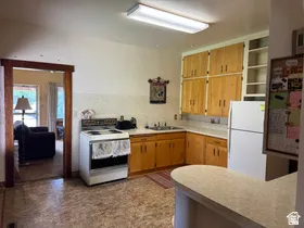 Kitchen featuring wood-finish cabinetry, solid surface countertops, a built-in sink, and integrated appliances
