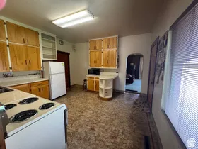 Kitchen featuring wood-finish cabinetry and a white electric range