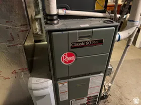 Rheem Classic 90 Plus furnace with PVC ventilation, accompanied by a white water softener and insulated ductwork