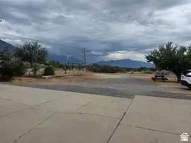 Paved concrete driveway extending to a gravel parking area