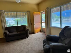 Living area with wall-to-wall carpeting and multiple windows offering natural light