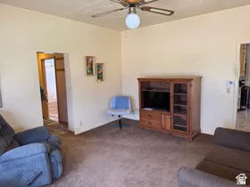 Carpeted interior with light-toned walls and a ceiling fan