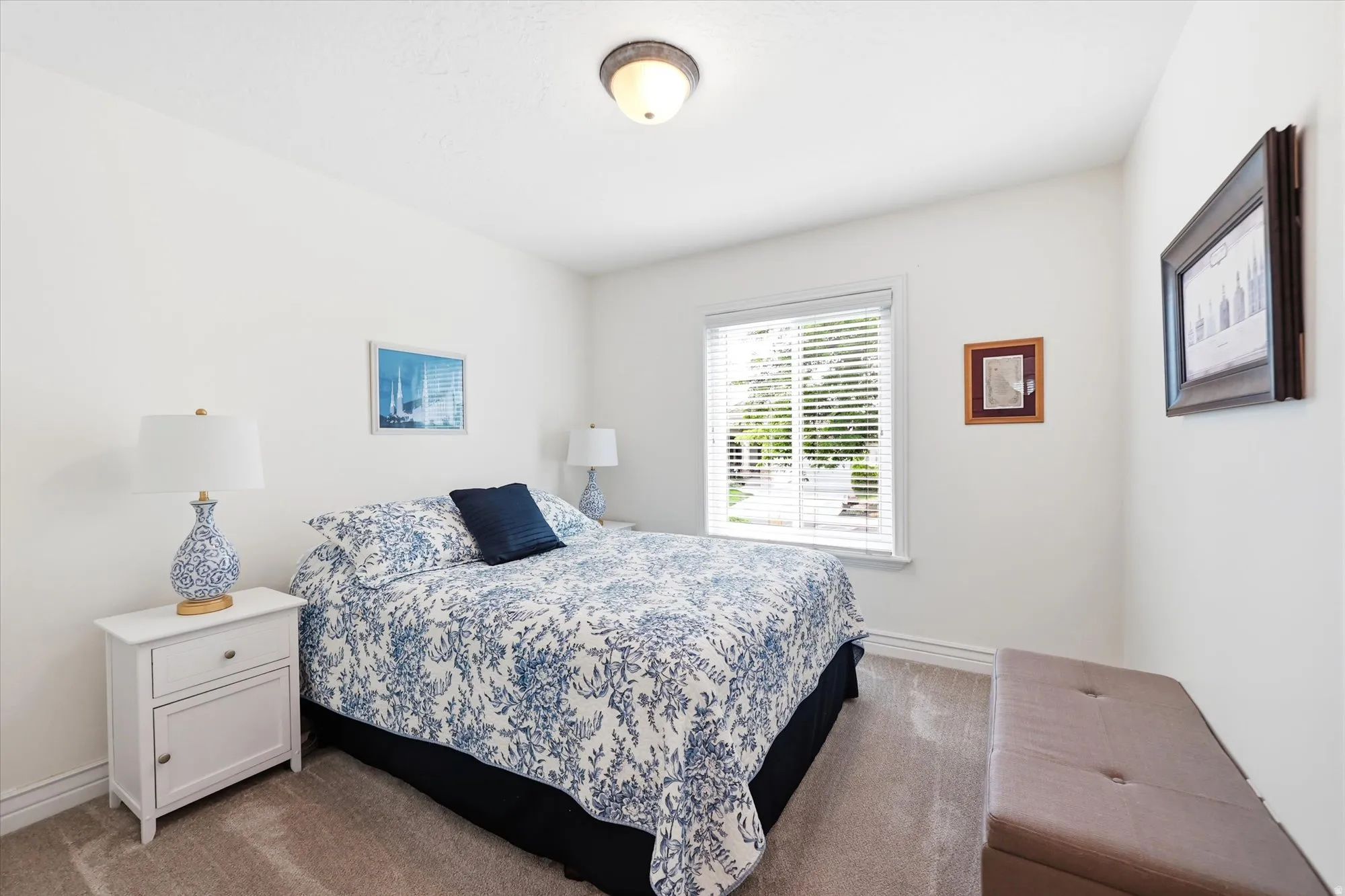 Bedroom featuring light neutral wall paint, a single window with blinds, and carpet flooring