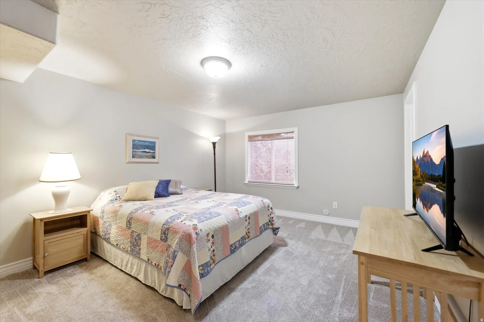Carpeted room featuring a ceiling-mounted light fixture, a window with horizontal blinds, and light gray wall paint