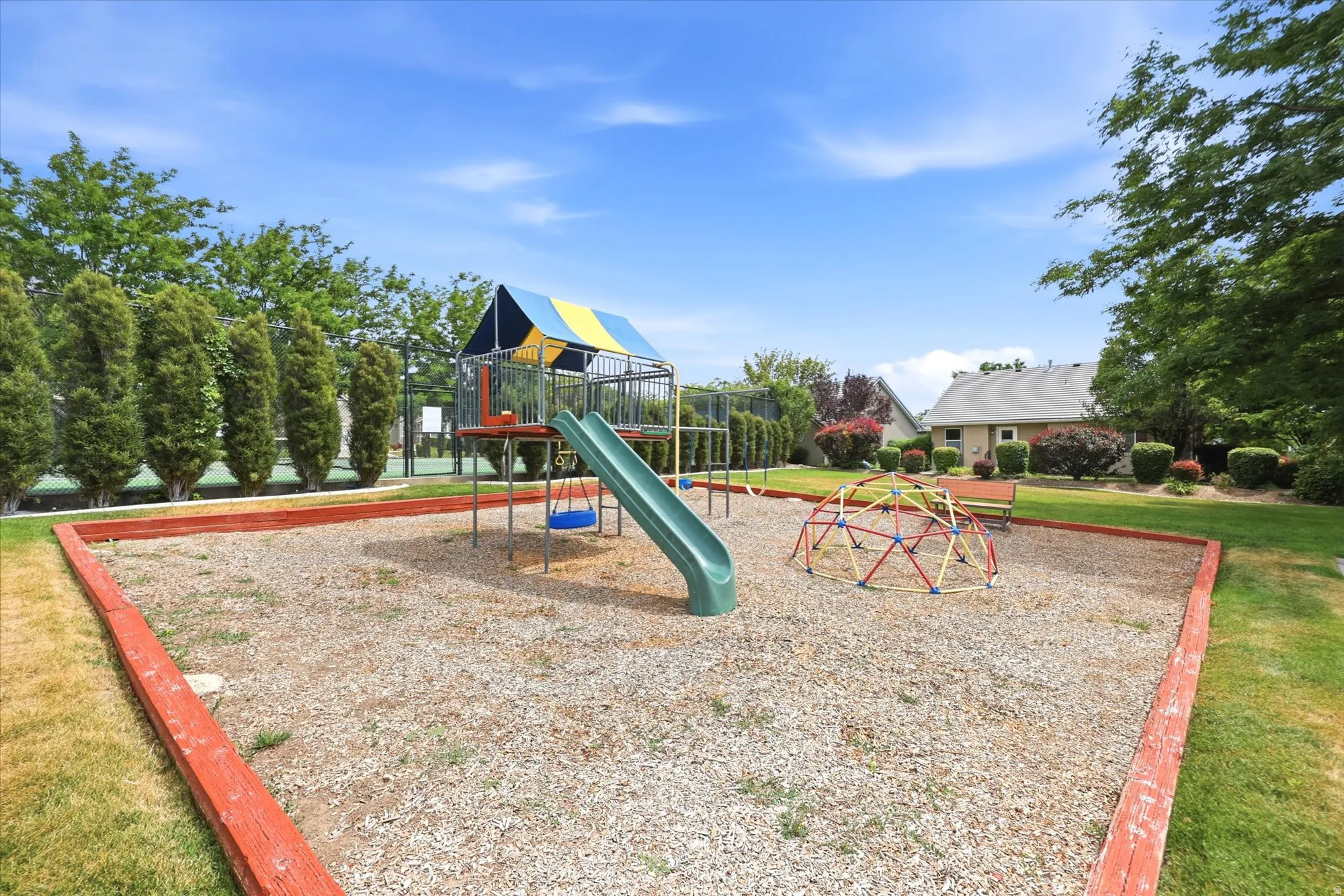 HOA Community playground featuring a slide, swings, and climbing dome