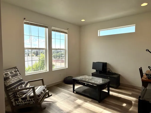 Room featuring wood-finish flooring, recessed lighting, and multiple windows providing natural illumination
