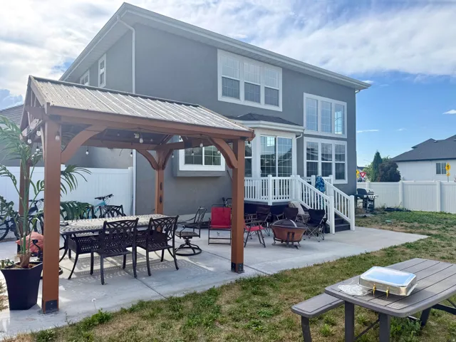 Expansive concrete patio featuring a wood-frame gazebo with a metal roof
