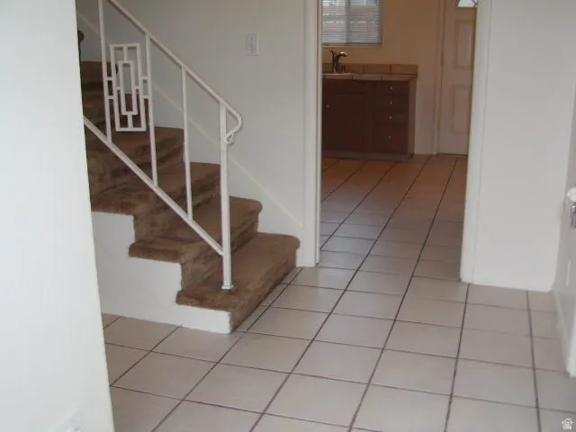 Carpeted staircase with an ornate white metal railing