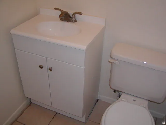 White vanity with integrated sink, bronze-finish faucet, and coordinating hardware