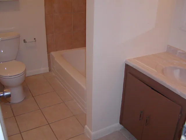 Bathroom with a built-in vanity featuring a brown wood-finish cabinet and integrated sink