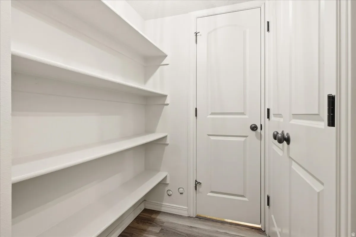 Built-in shelving, white paneled doors, and wood-finish flooring
