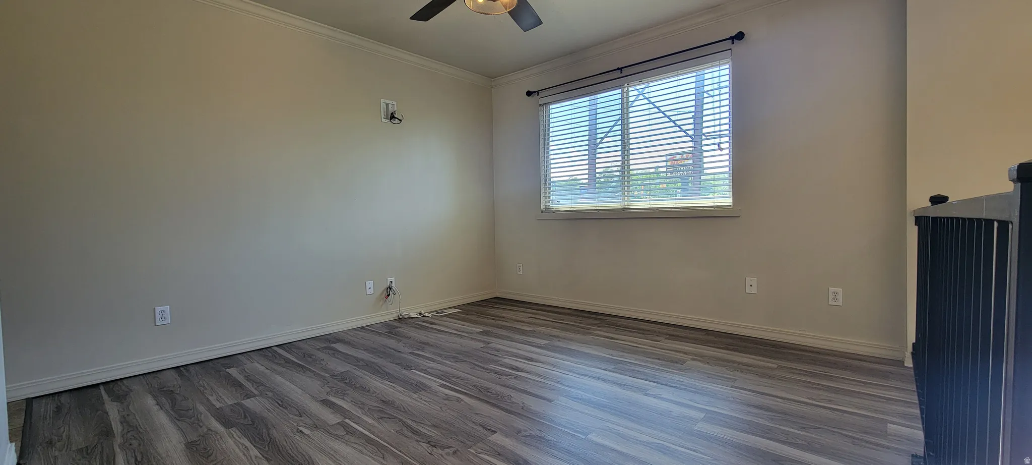 Neutral wall tones with crown molding and wood-finish flooring