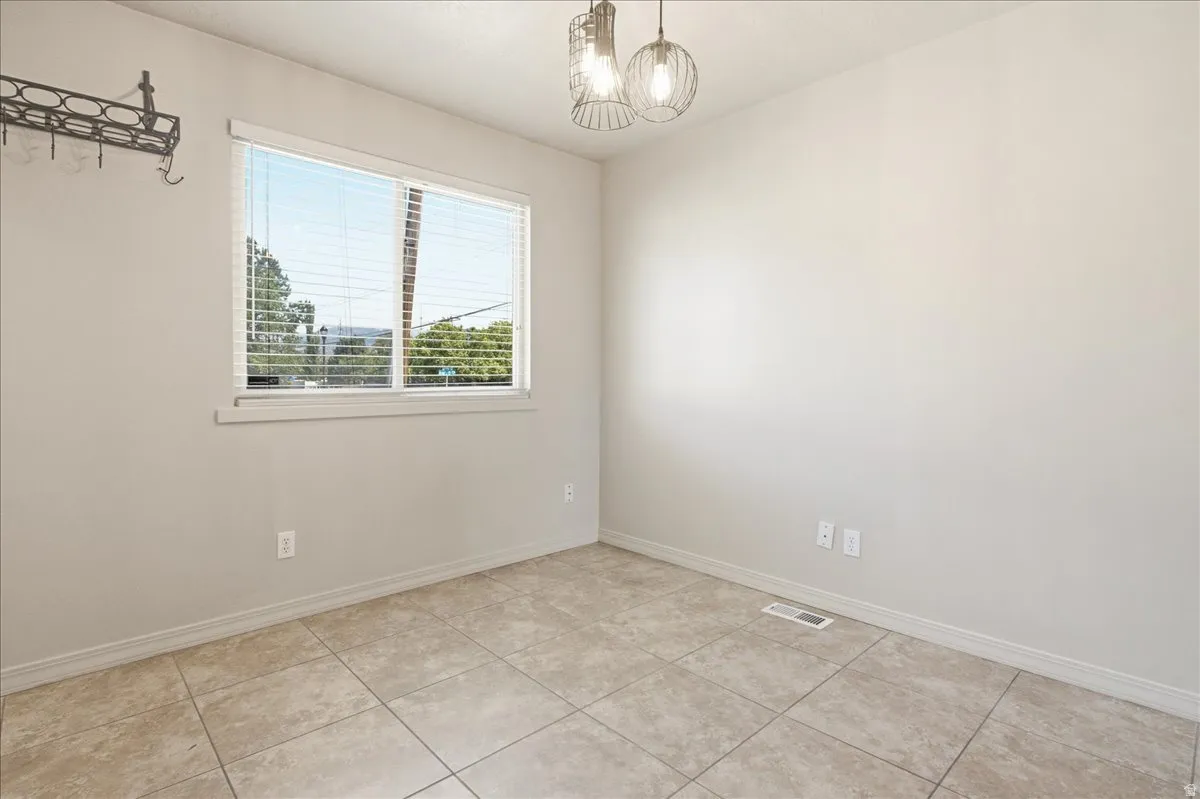 Recessed lighting, tile flooring, and a large window with blinds