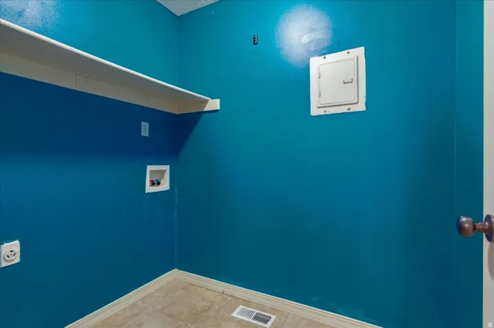 Built-in shelving, tile flooring, and utility hookups