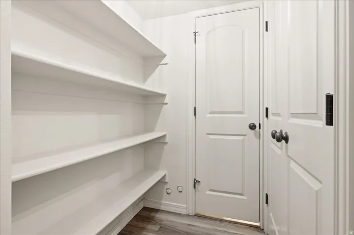 Built-in shelving, white paneled doors, and wood-finish flooring