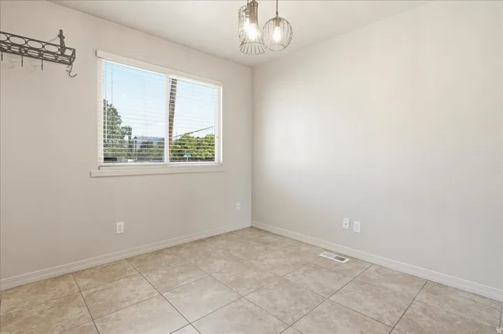 Recessed lighting, tile flooring, and a large window with blinds