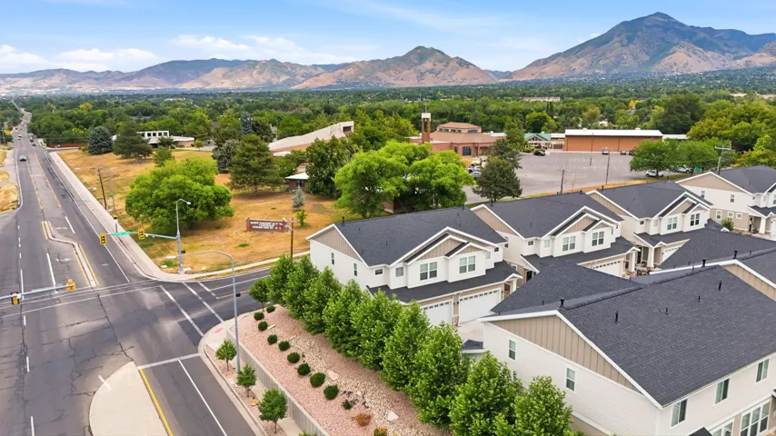 Contemporary residential development featuring a row of multi-story homes with dark shingle roofs and light-toned siding