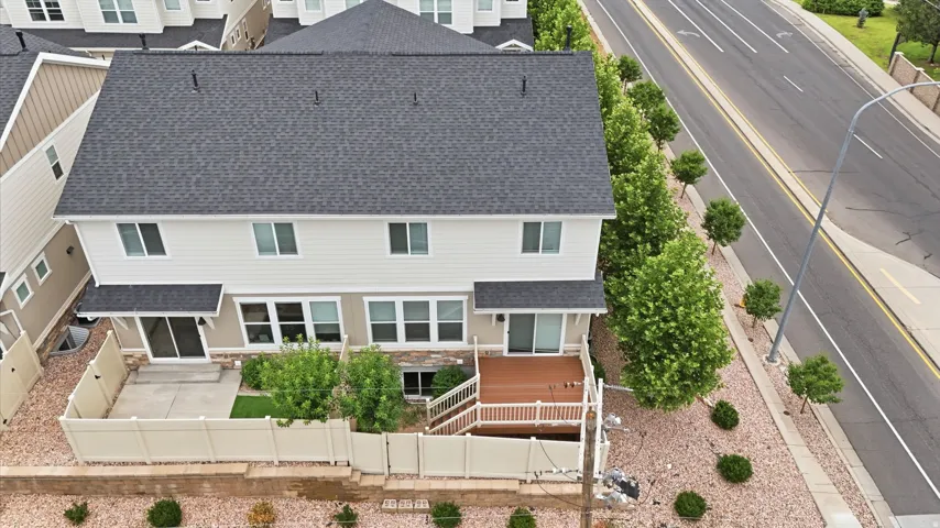 Rear exterior featuring a composite deck, a lower patio area, and a fenced yard