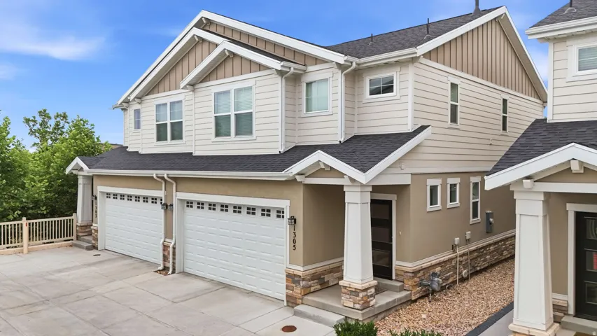 Contemporary multi-level exterior featuring neutral-toned siding, dark roofing, and stone accents