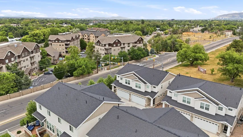 Contemporary townhomes featuring light-colored siding, dark-shingled roofs, and attached two-car garages
