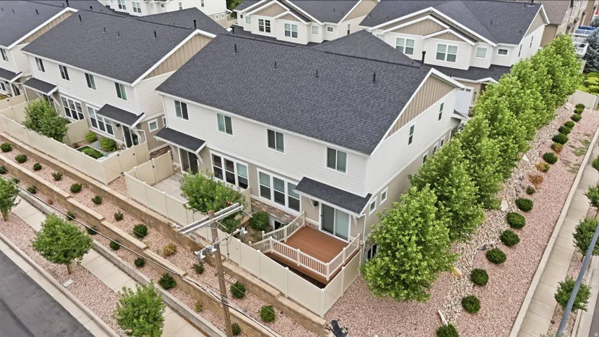 Aerial perspective of a multi-unit property featuring light-colored siding and dark shingle roofing