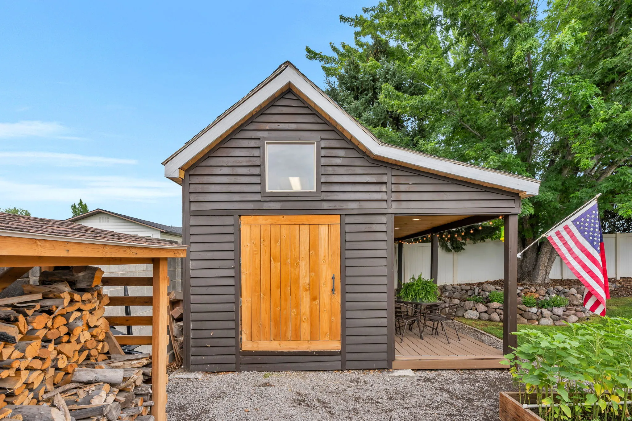 Freestanding outbuilding with dark horizontal siding and a gambrel-style roof