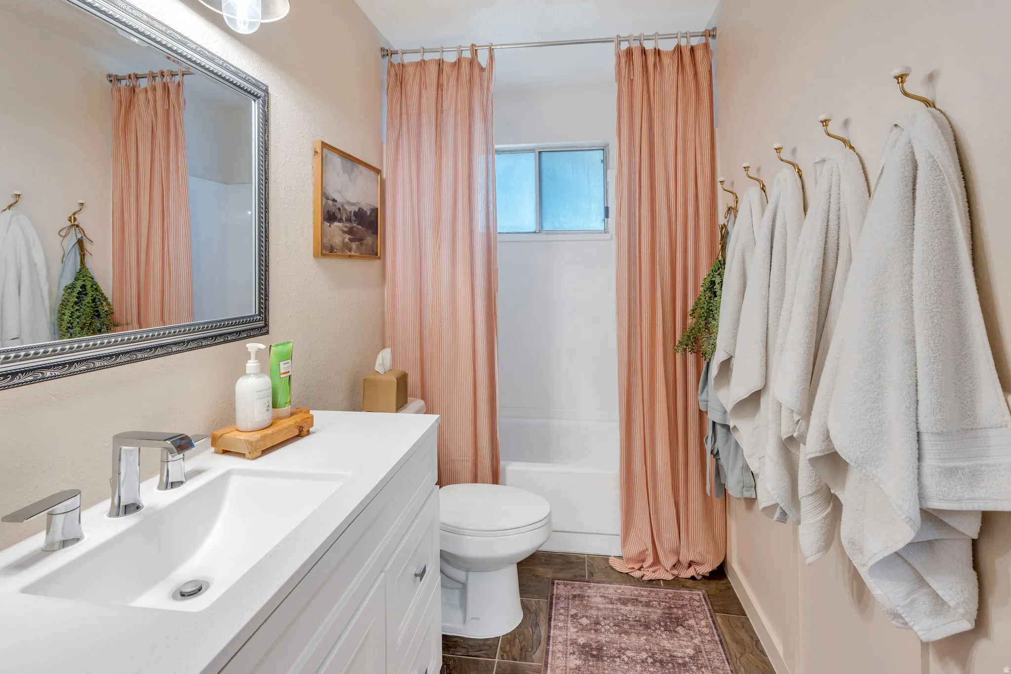 Bathroom featuring a white vanity with integrated sink, chrome-finish faucet, and an ornate framed mirror