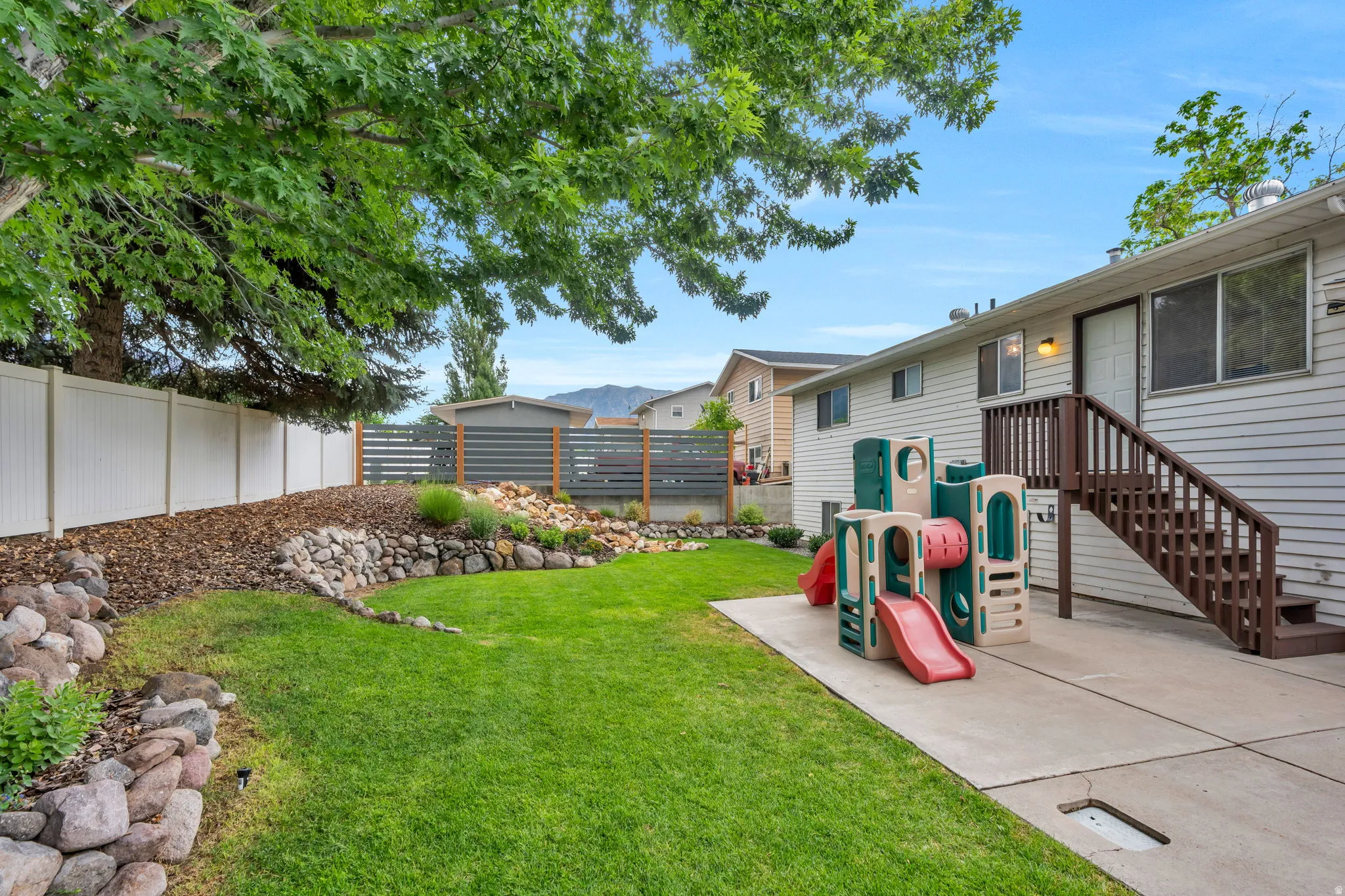 Expansive backyard with a manicured lawn and mature trees
