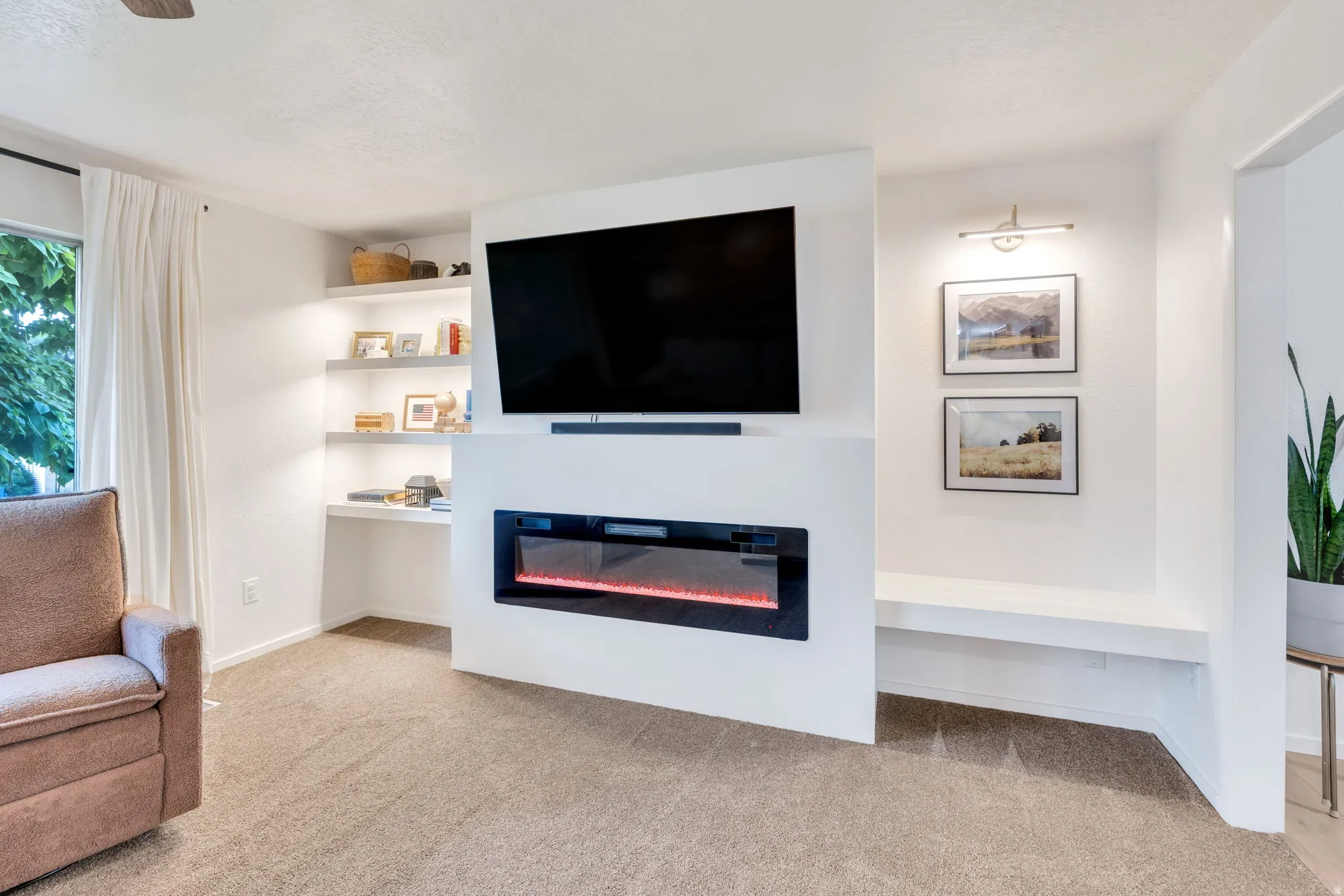 Integrated media wall featuring a mounted television and an electric fireplace
