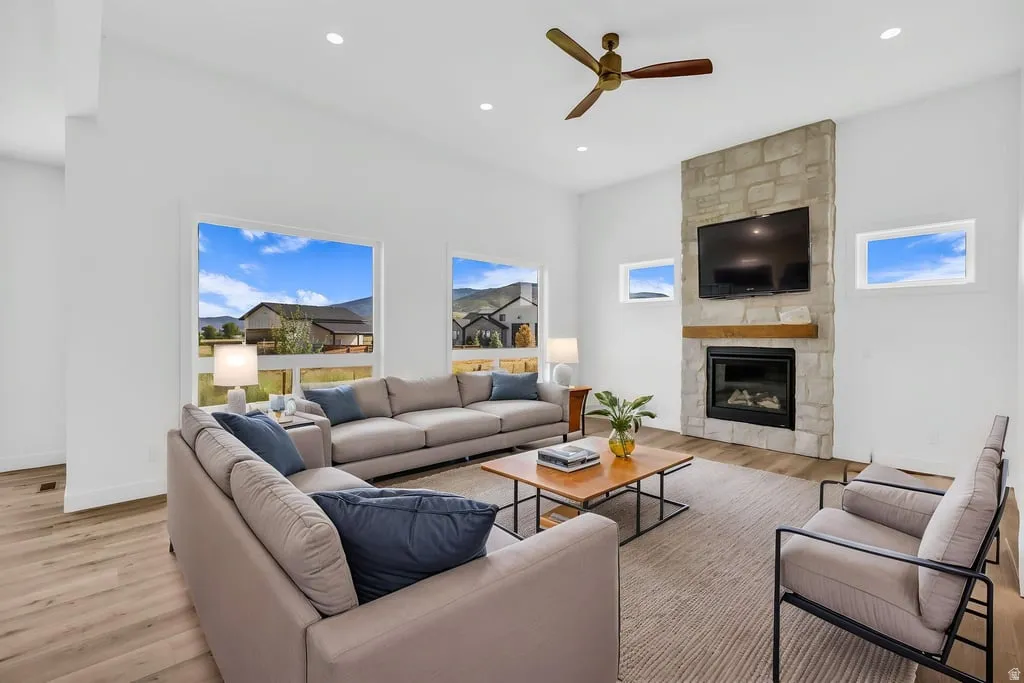 Living area featuring a stone-clad fireplace with a wood mantel, recessed lighting, and a ceiling fan